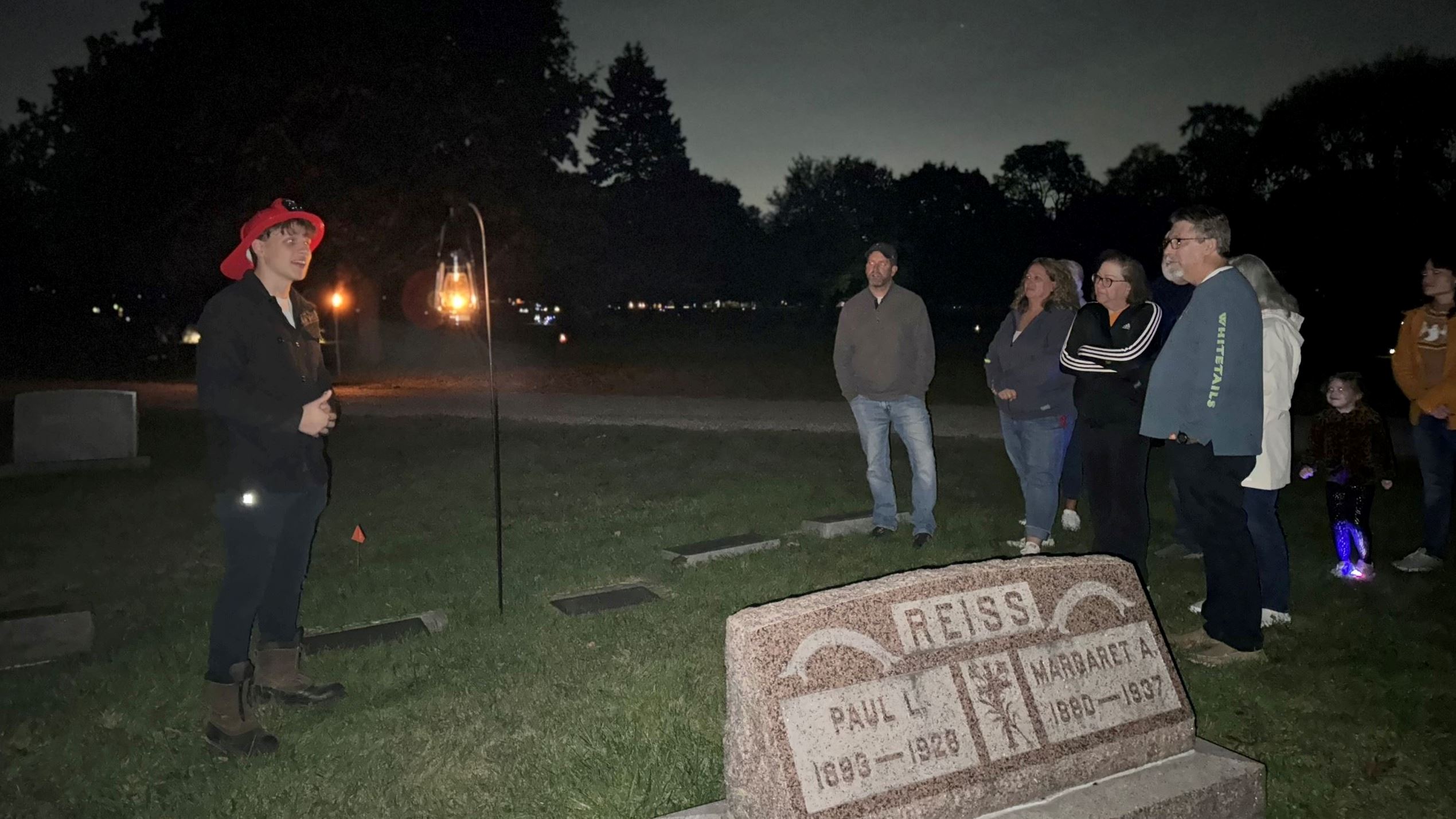 Boy in fire hat speaking to crowd at Cemetery Walk